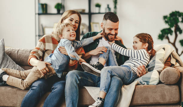 Happy family mother father and kids at home on the couch